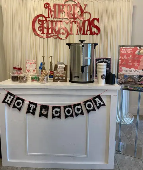 Hot cocoa bar with a Merry Christmas sign