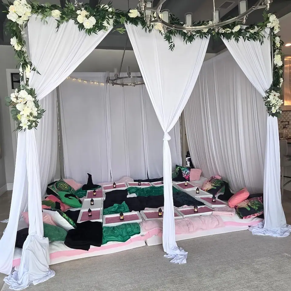 White draped canopy sleepover with floor bedding and greenery