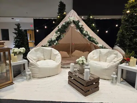 Corporate event lounge with a bell tent, cream bean bags and evergreen trees