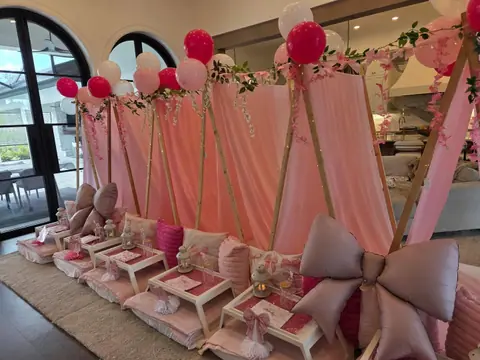 Blush sleepover teepees with big bows lined up by a window