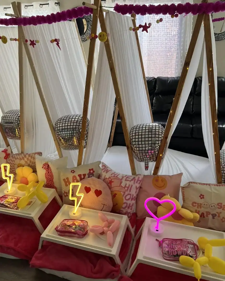 A room filled with pink and yellow decorations and teepee tents.